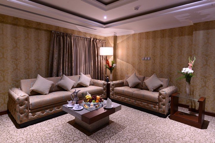 Al Aqeeq Madinah Hotel マディーナ エクステリア 写真 The photo depicts a well-decorated living room. It features two elegant sofas with decorative pillows, positioned across from each other. A coffee table is centered between them, adorned with a variety of fruits and possibly some snacks or beverages.